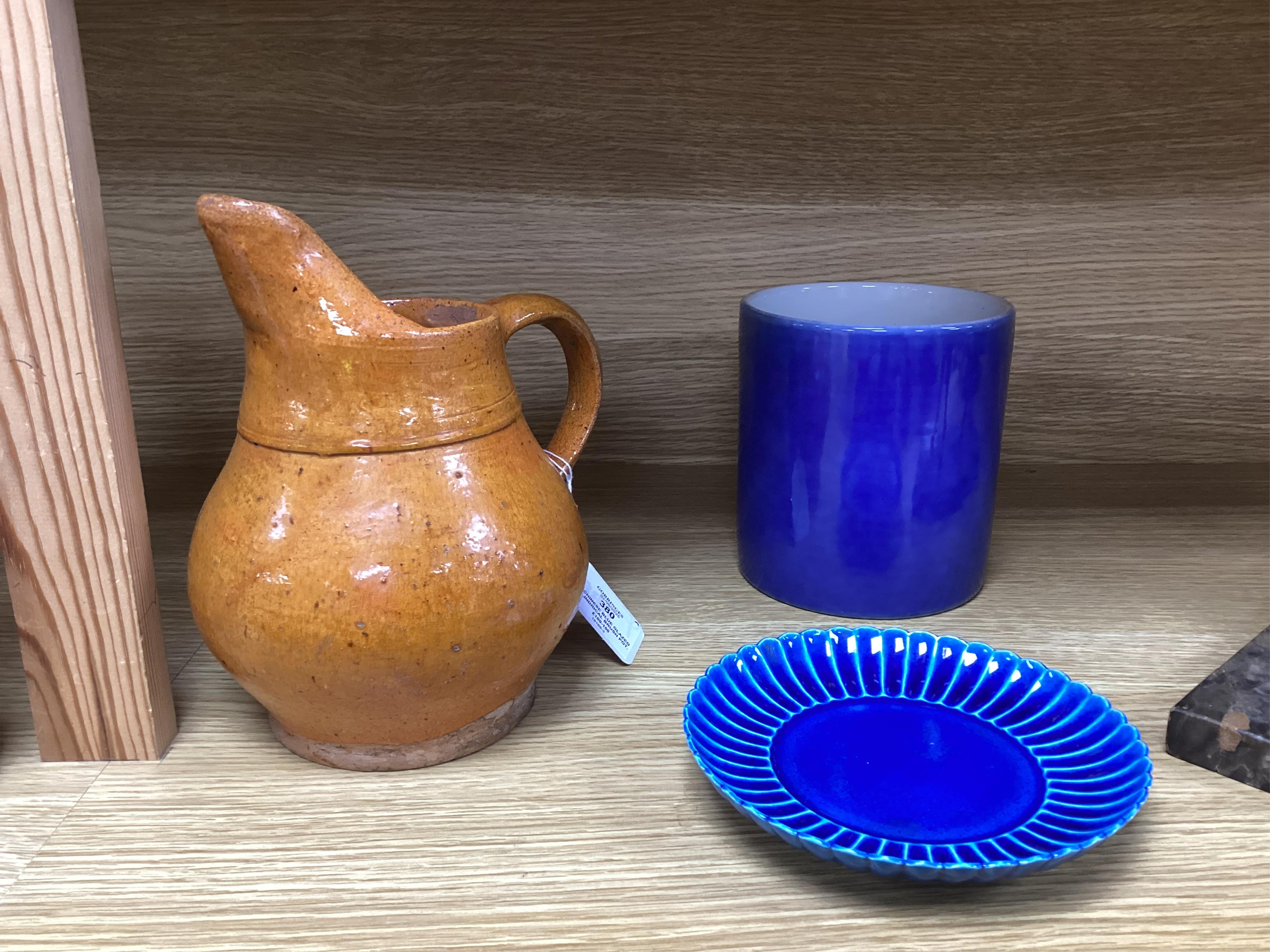 A Chinese blue glazed cylindrical brush pot, Kangxi mark but later, a similar saucer, Qianlong mark but later and a terracotta jug, 21cm